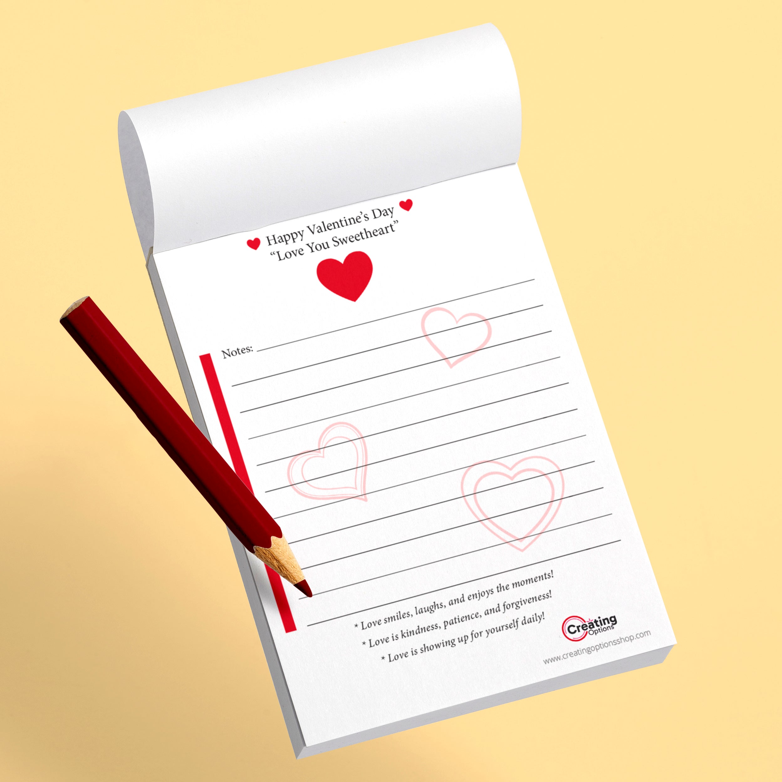 Valentine's Day themed notepad with hearts and a pencil on a beige background